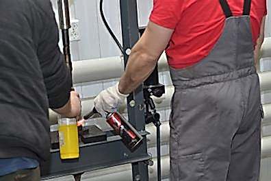 Мастер наносит антишумовое покрытие на кузов