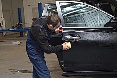 Механик наносит слой керамики на правую дверь