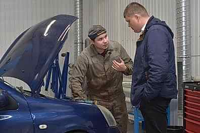 Оценщик производит осмотр подкапотного пространства