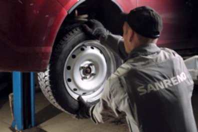 механик балансирует левое переднее колесо (Санрено)