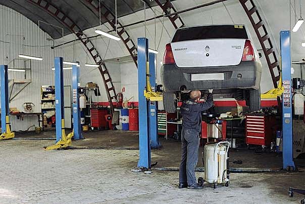 Мастер откручивает коробку передач