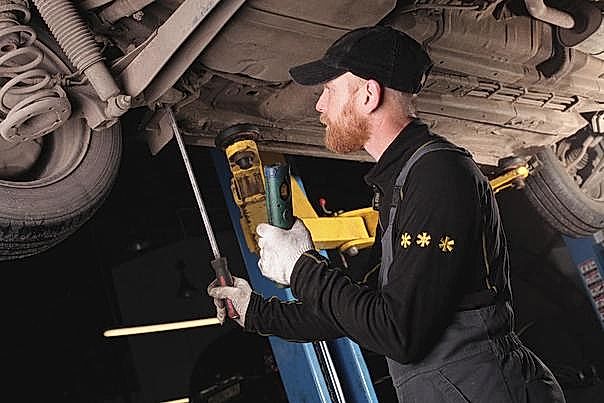 механик осматривает рейку на подъемнике