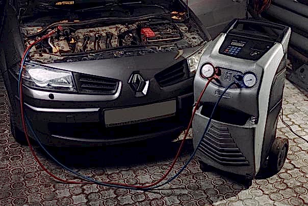 Мастер ремонтирует автокондиционер