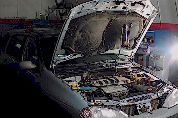 Автомеханик занят проблемами у клиента автосервиса