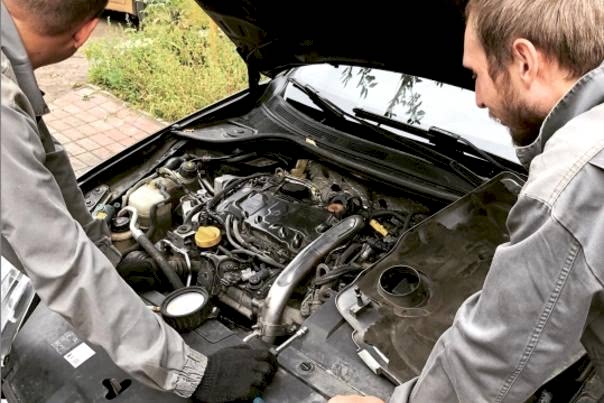 автомеханики меняют опору движка